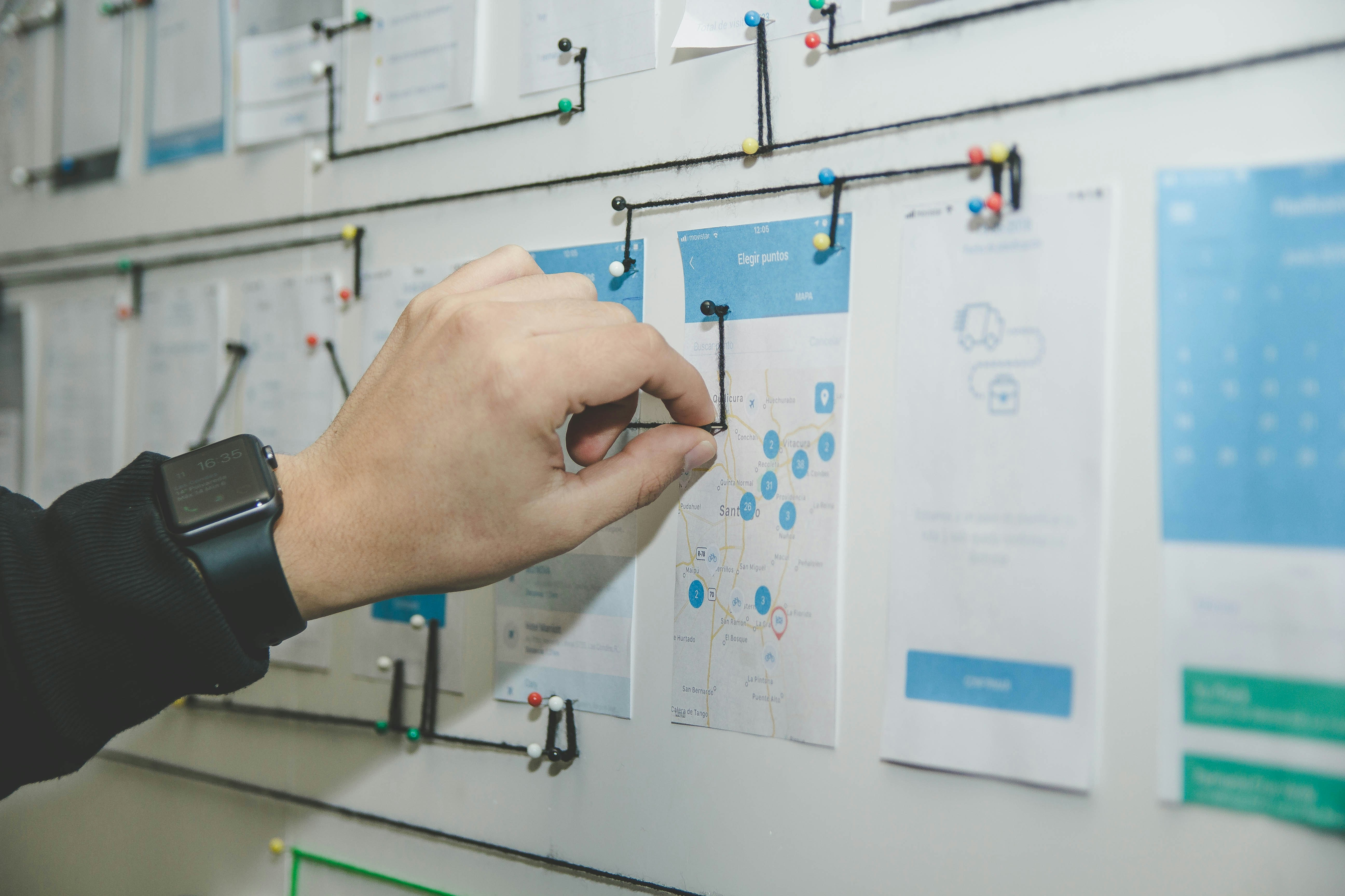 A person working on a blue and white paper on a board